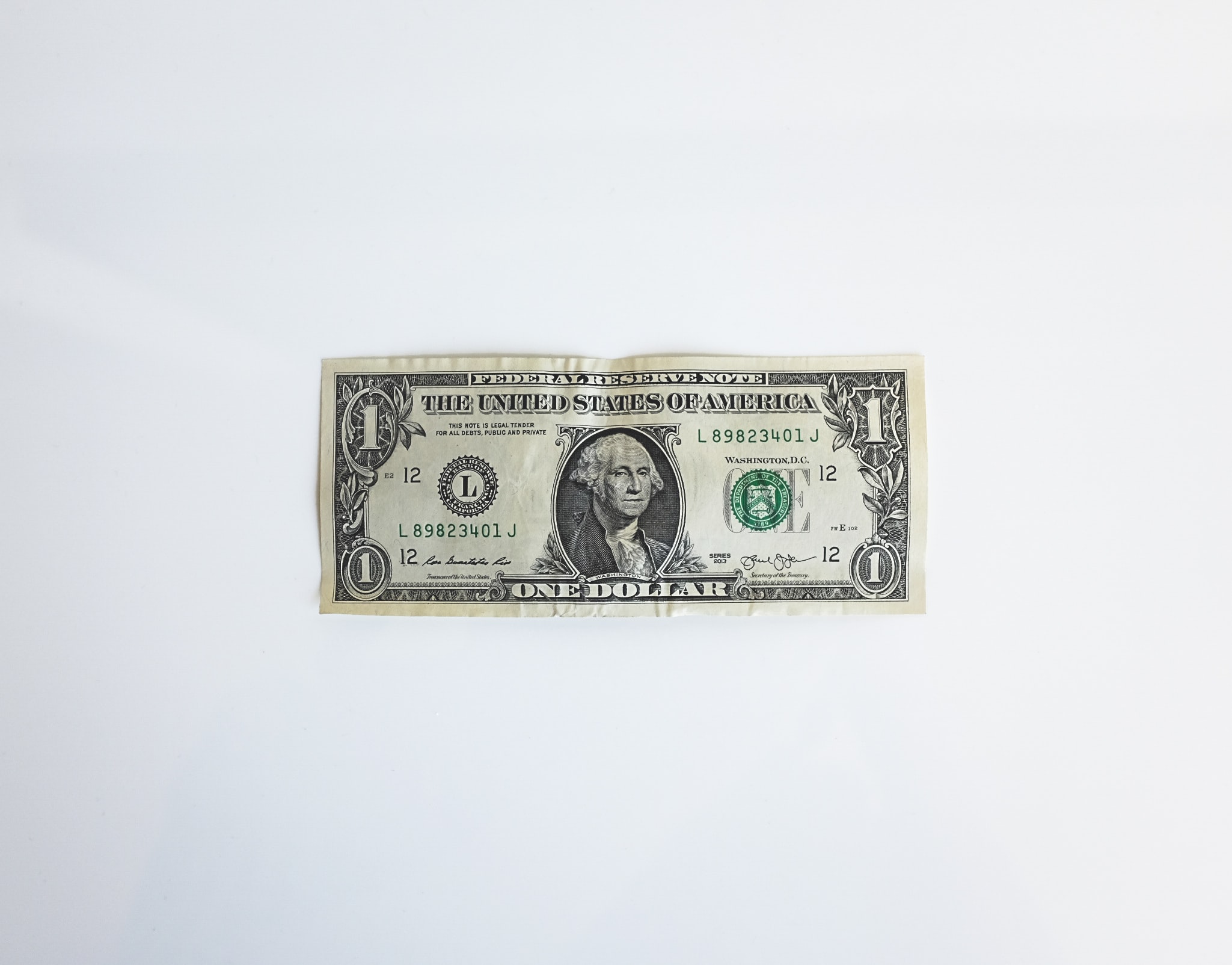 one dollar bill laying flat on a white background